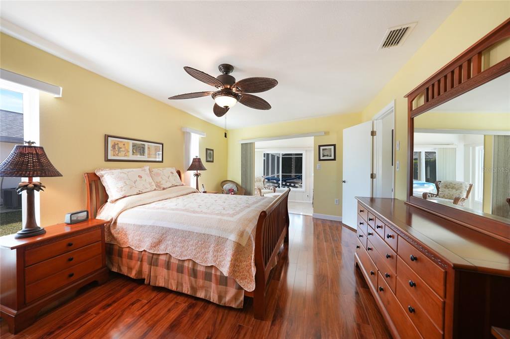 18097 Brazil Avenue Port Charlotte, FL 33948 - Photo 16 of 37 a large bedroom with a bed and wooden floor