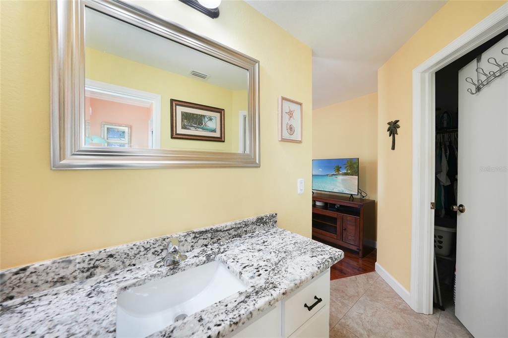 18097 Brazil Avenue Port Charlotte, FL 33948 - Photo 18 of 37 a bathroom with a granite countertop sink a mirror and a shower
