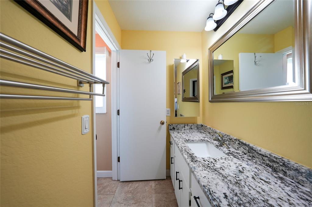 18097 Brazil Avenue Port Charlotte, FL 33948 - Photo 19 of 37 a bathroom with a granite countertop sink and a mirror