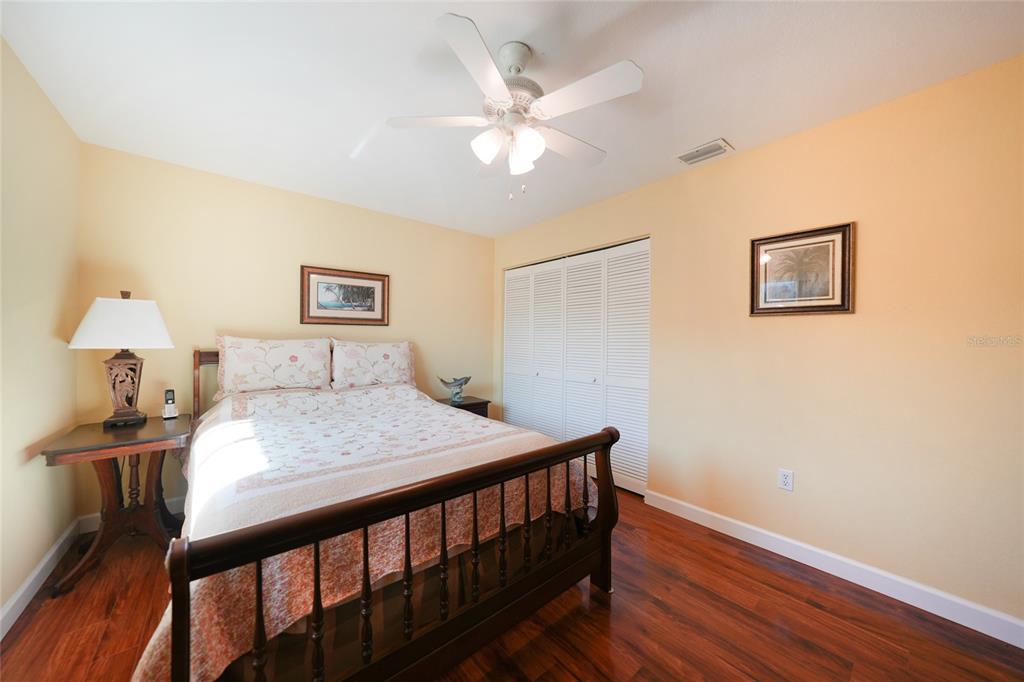 18097 Brazil Avenue Port Charlotte, FL 33948 - Photo 22 of 37 a bedroom with a bed and wooden floor