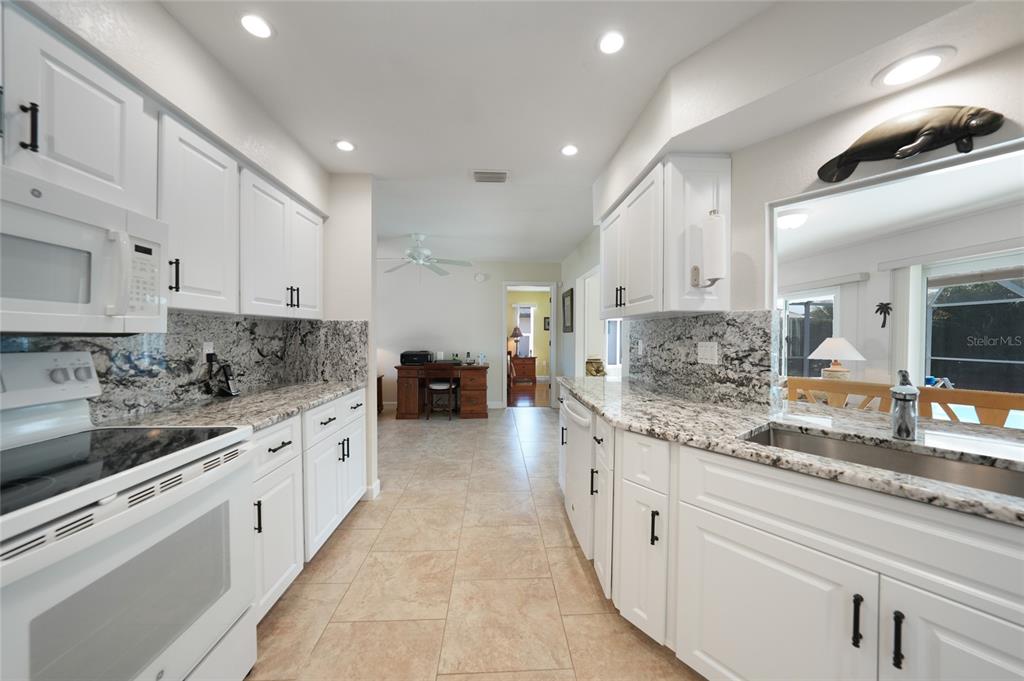 18097 Brazil Avenue Port Charlotte, FL 33948 - Photo 9 of 37 a large kitchen with stainless steel appliances lots of counter space and wooden floor