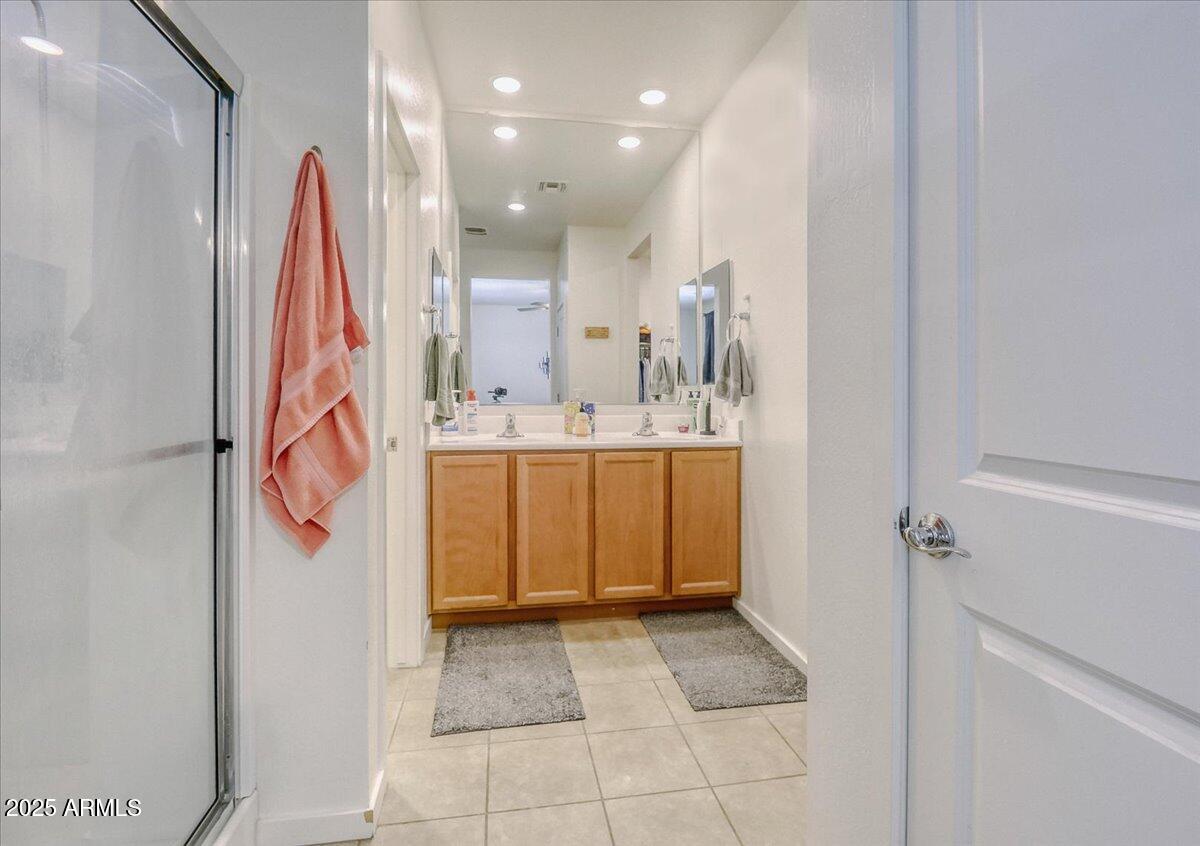 9825 West Trumbull Road Tolleson, AZ 85353 - Photo 12 of 19 a bathroom with a sink a mirror and a shower