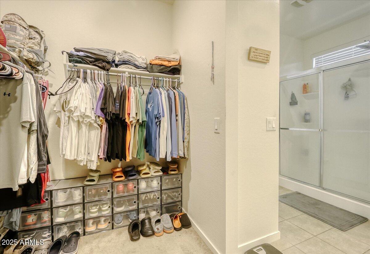 9825 West Trumbull Road Tolleson, AZ 85353 - Photo 14 of 19 a view of walk in closet with clothes and shoes