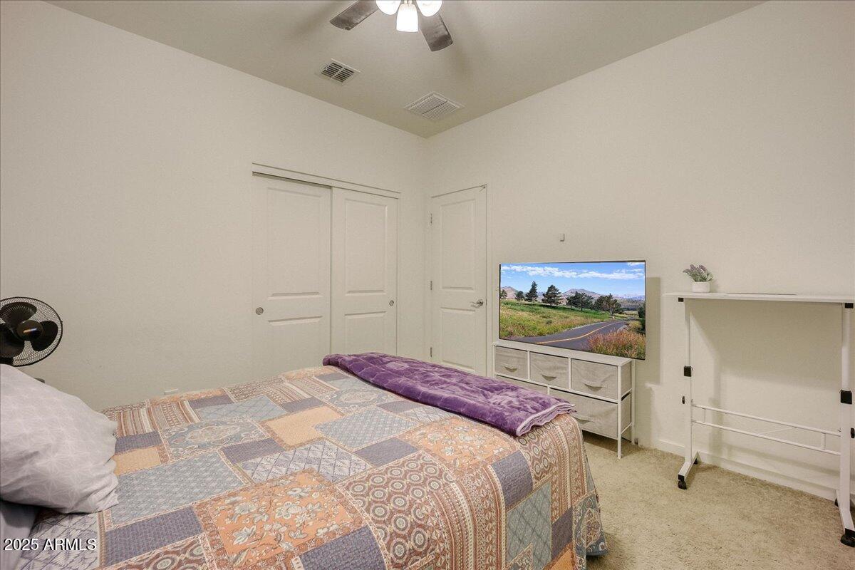9825 West Trumbull Road Tolleson, AZ 85353 - Photo 15 of 19 a bedroom with a bed and a chandelier
