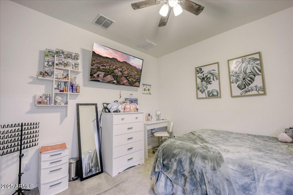 9825 West Trumbull Road Tolleson, AZ 85353 - Photo 16 of 19 a bedroom with a bed and a flat screen tv