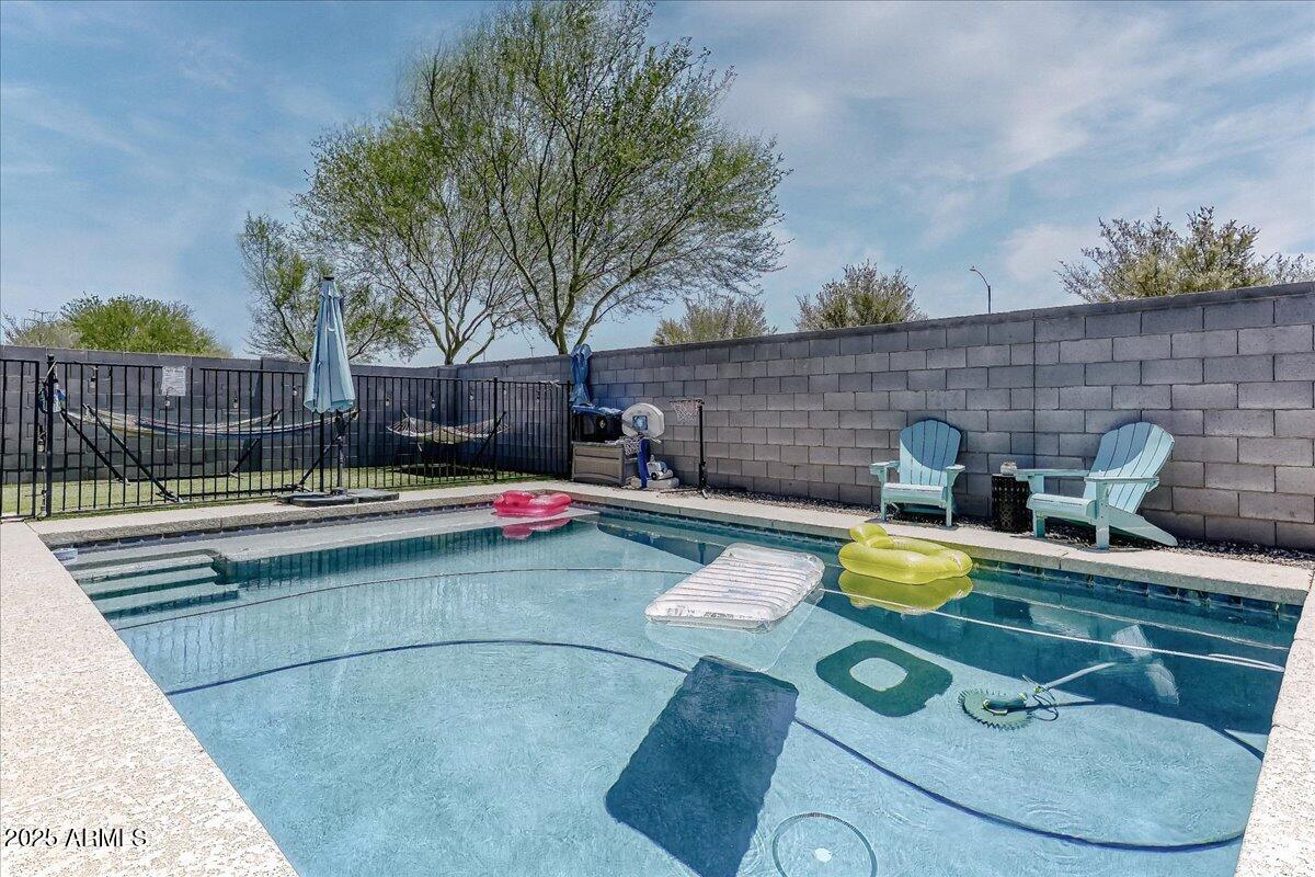 9825 West Trumbull Road Tolleson, AZ 85353 - Photo 19 of 19 a view of backyard with swimming pool and seating