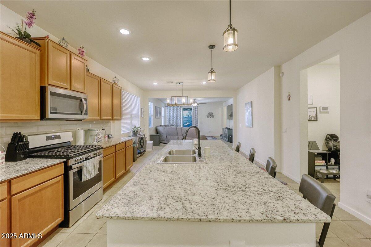 9825 West Trumbull Road Tolleson, AZ 85353 - Photo 5 of 19 a large kitchen with kitchen island a sink stove and refrigerator