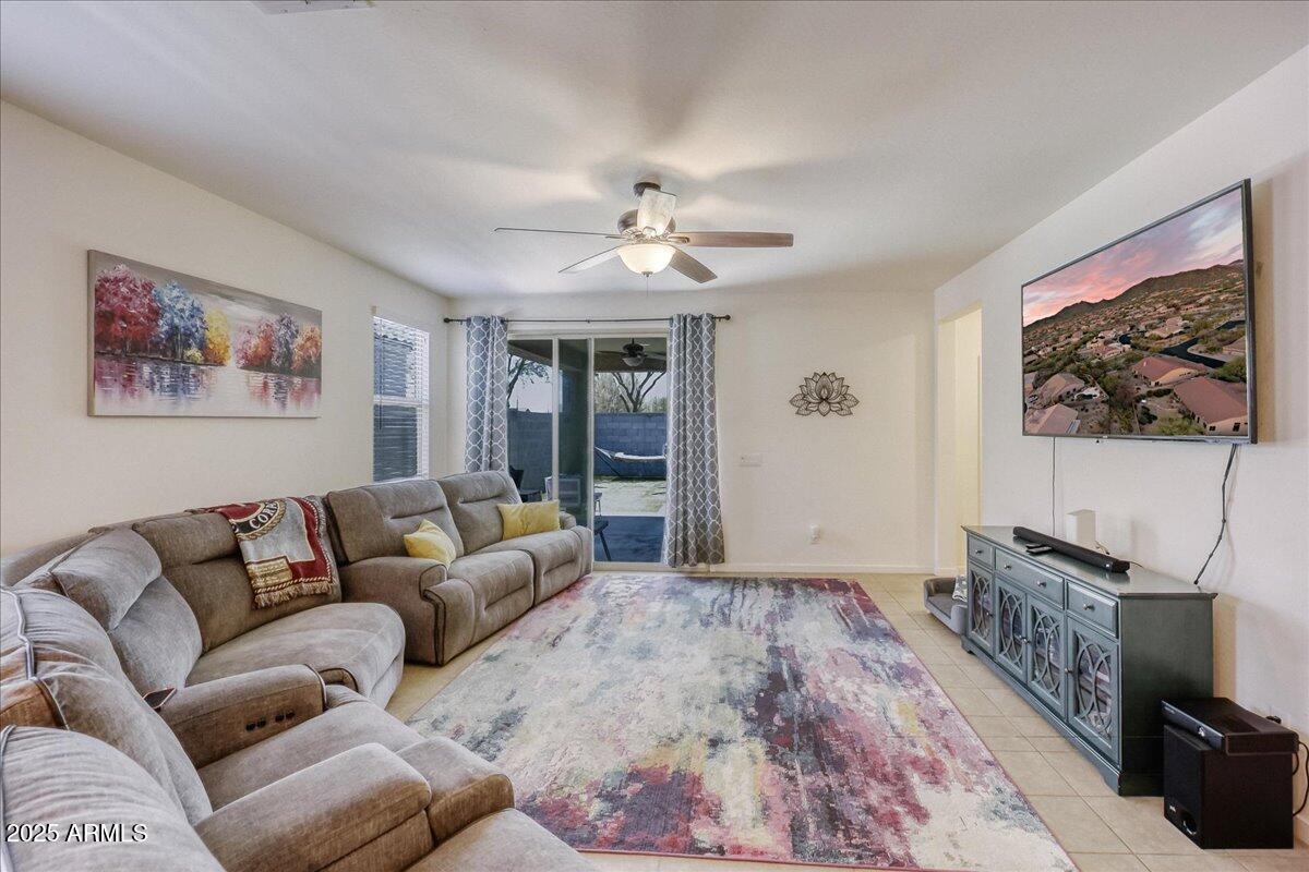 9825 West Trumbull Road Tolleson, AZ 85353 - Photo 7 of 19 a living room with furniture a ceiling fan and a window