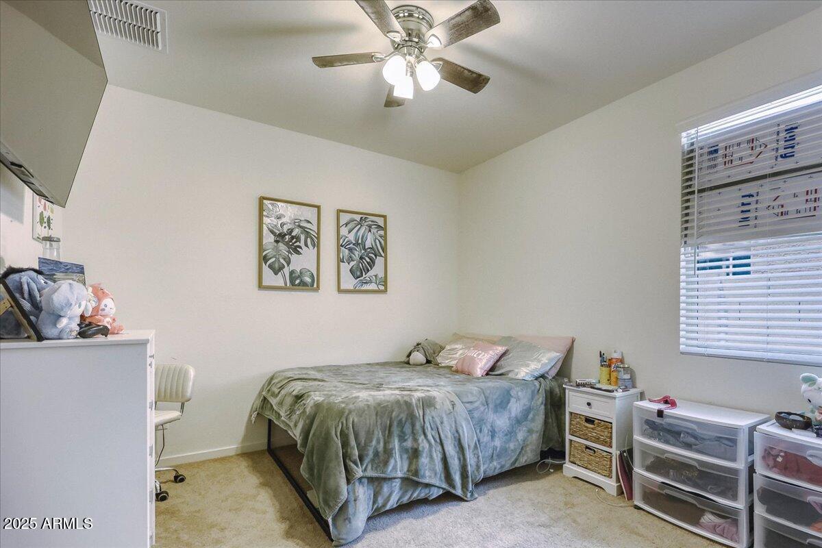 9825 West Trumbull Road Tolleson, AZ 85353 - Photo 8 of 19 a bedroom with a bed and a chandelier