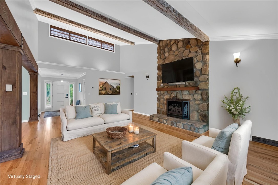 433 Latham Road Easley, SC 29640 - Photo 22 of 50 An inviting gathering space features an impressive stone fireplace and natural wood flooring, creating a cozy ambiance.