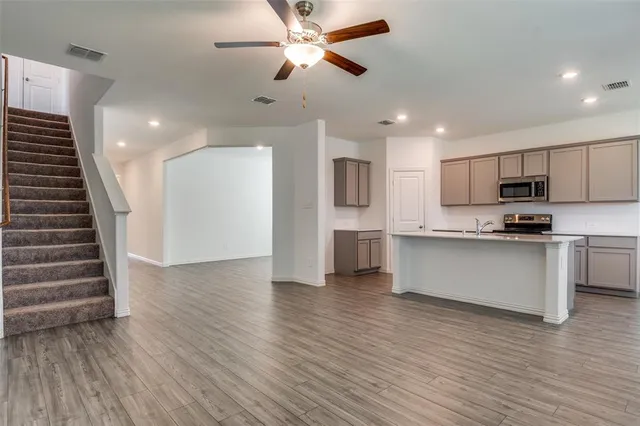 a view of kitchen with refrigerator microwave and stove top oven