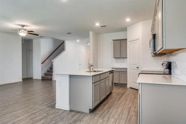 a kitchen with stainless steel appliances granite countertop a sink stove and wooden floor