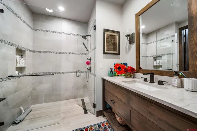 a bathroom with a double vanity sink mirror and shower