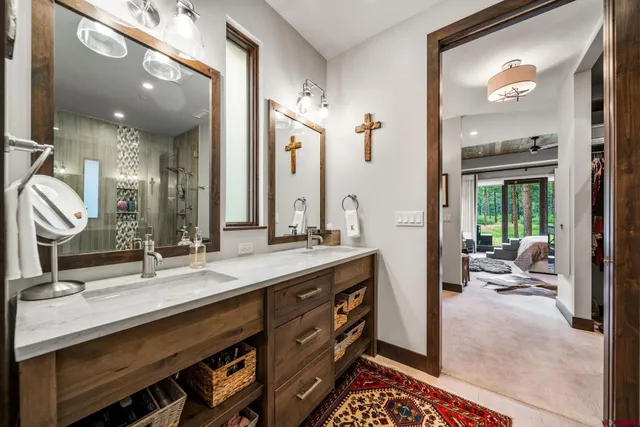 a bathroom with a double vanity sink a mirror and a shower