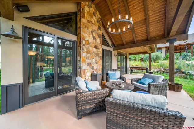 a living room with patio furniture and garden view