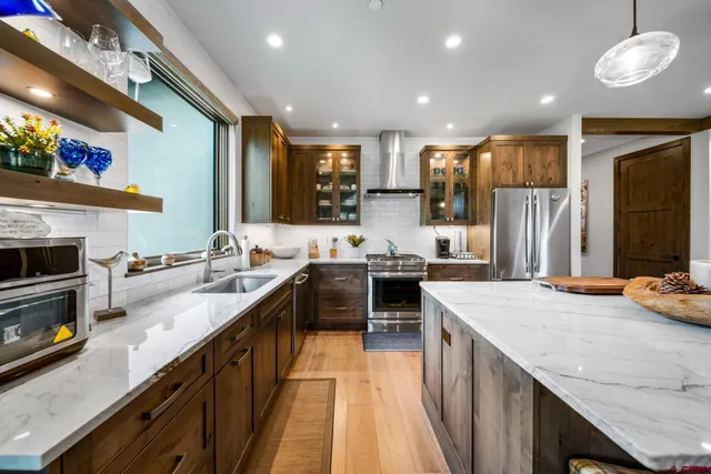 a kitchen with stainless steel appliances granite countertop a sink stove and refrigerator