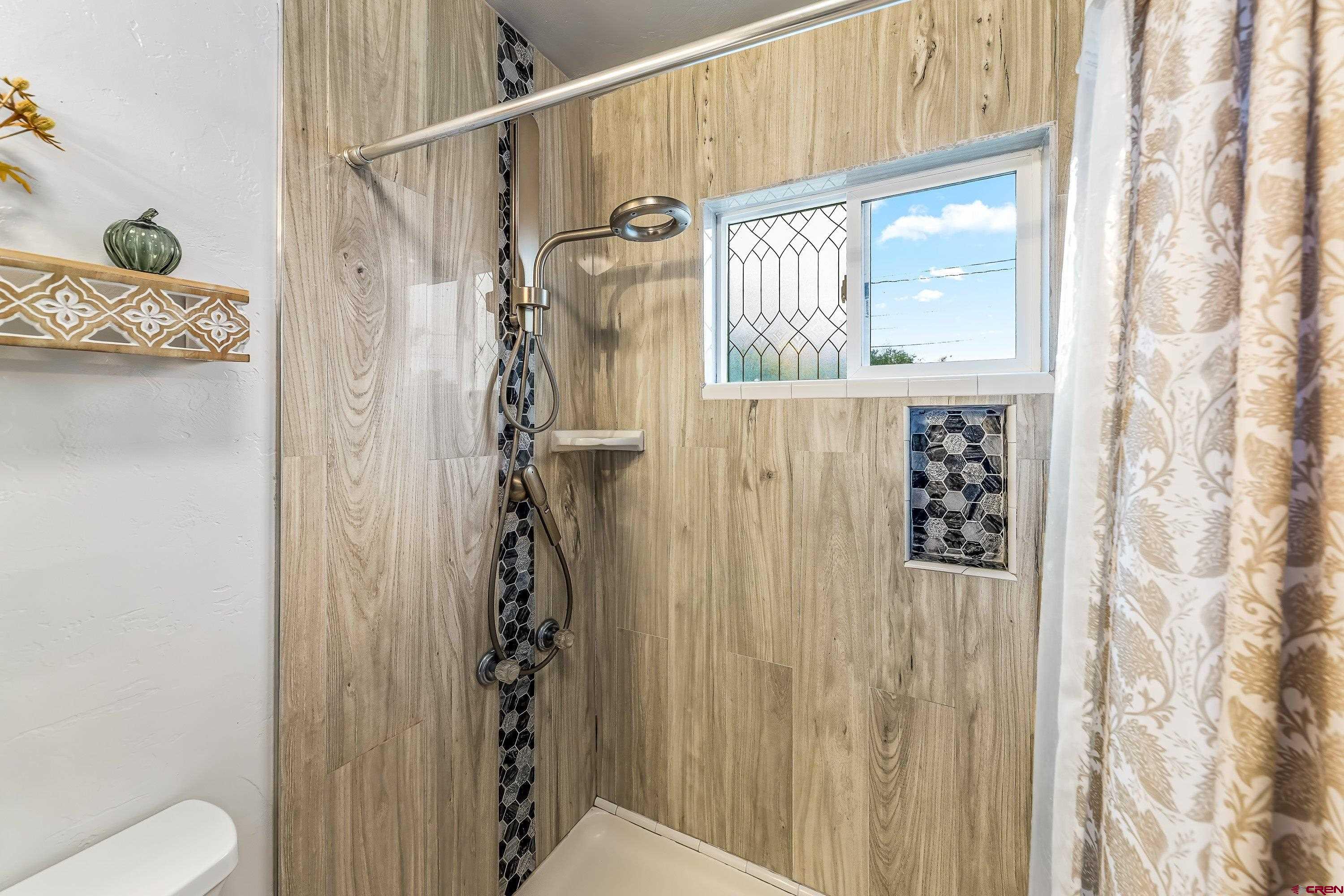 645 Leon Street Delta, CO 81416 - Photo 13 of 28 a bathroom with a shower curtain and a window