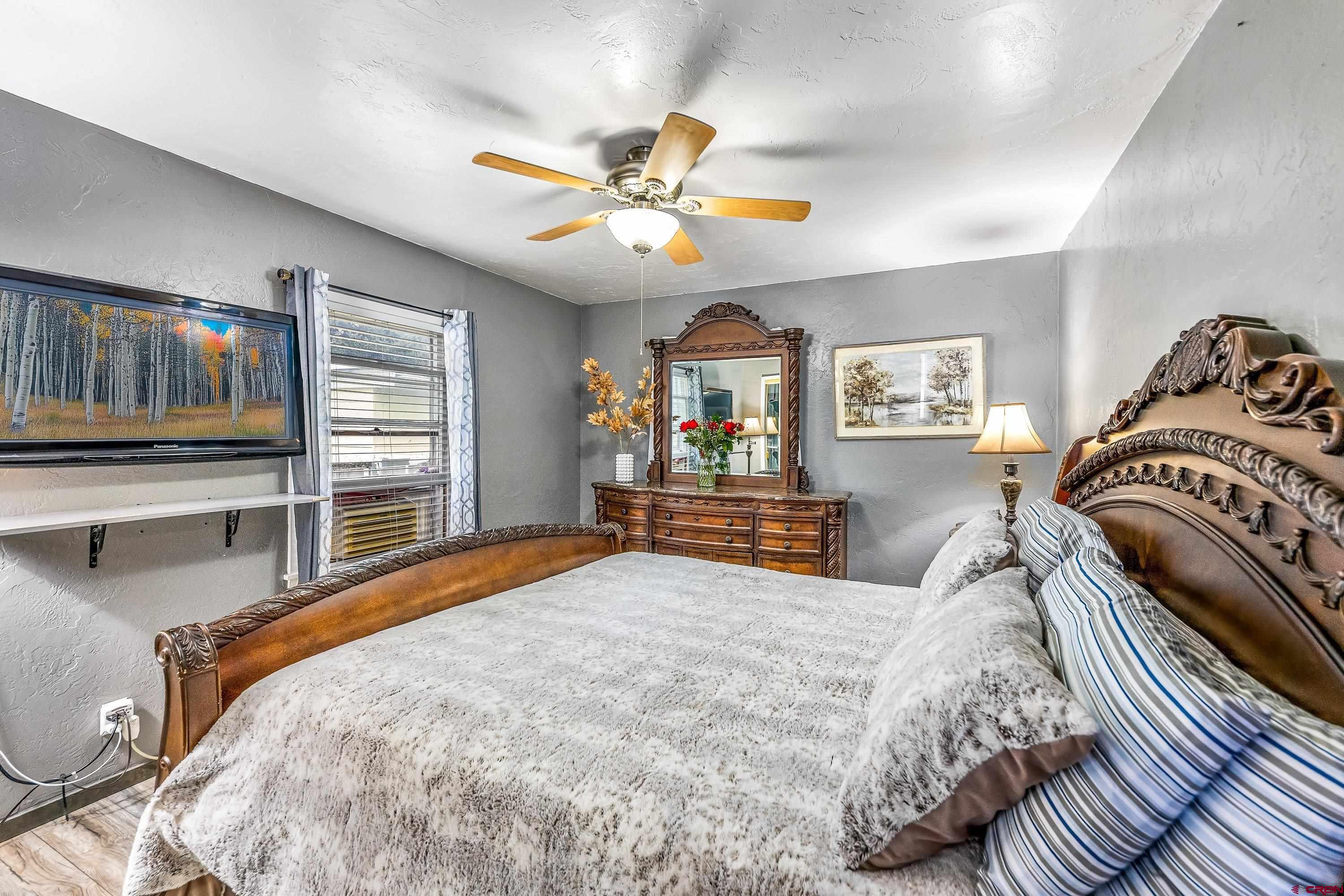 645 Leon Street Delta, CO 81416 - Photo 17 of 28 a bedroom with a large bed and a chandelier