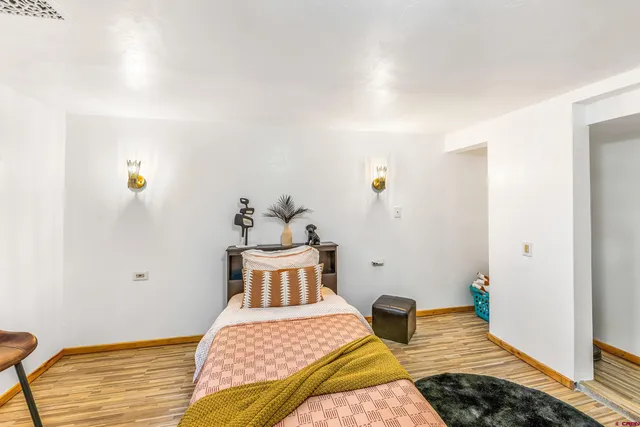 a bedroom with a bed and wooden floor