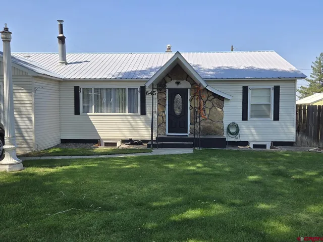 a front view of a house with a garden and yard