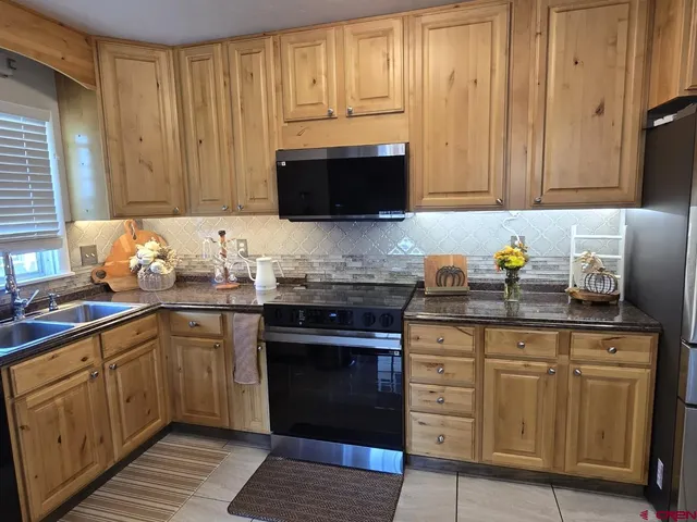 a kitchen with granite countertop cabinets stainless steel appliances and wooden cabinets