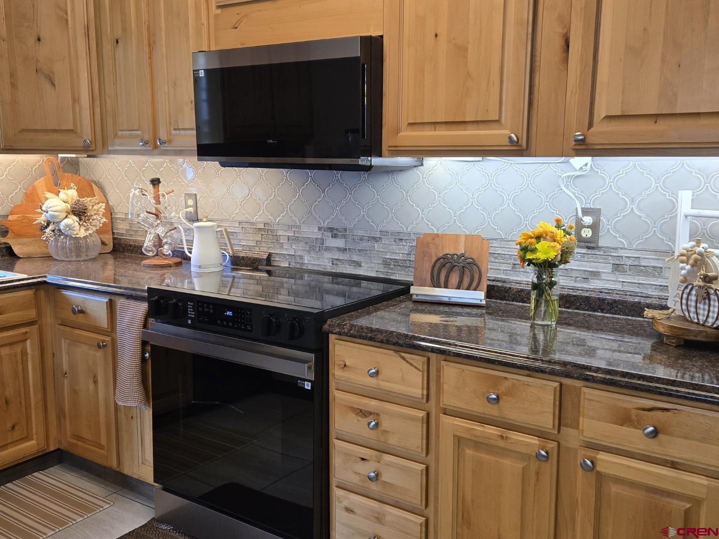 645 Leon Street Delta, CO 81416 - Photo 6 of 28 a kitchen with stainless steel appliances granite countertop a sink a stove and a microwave
