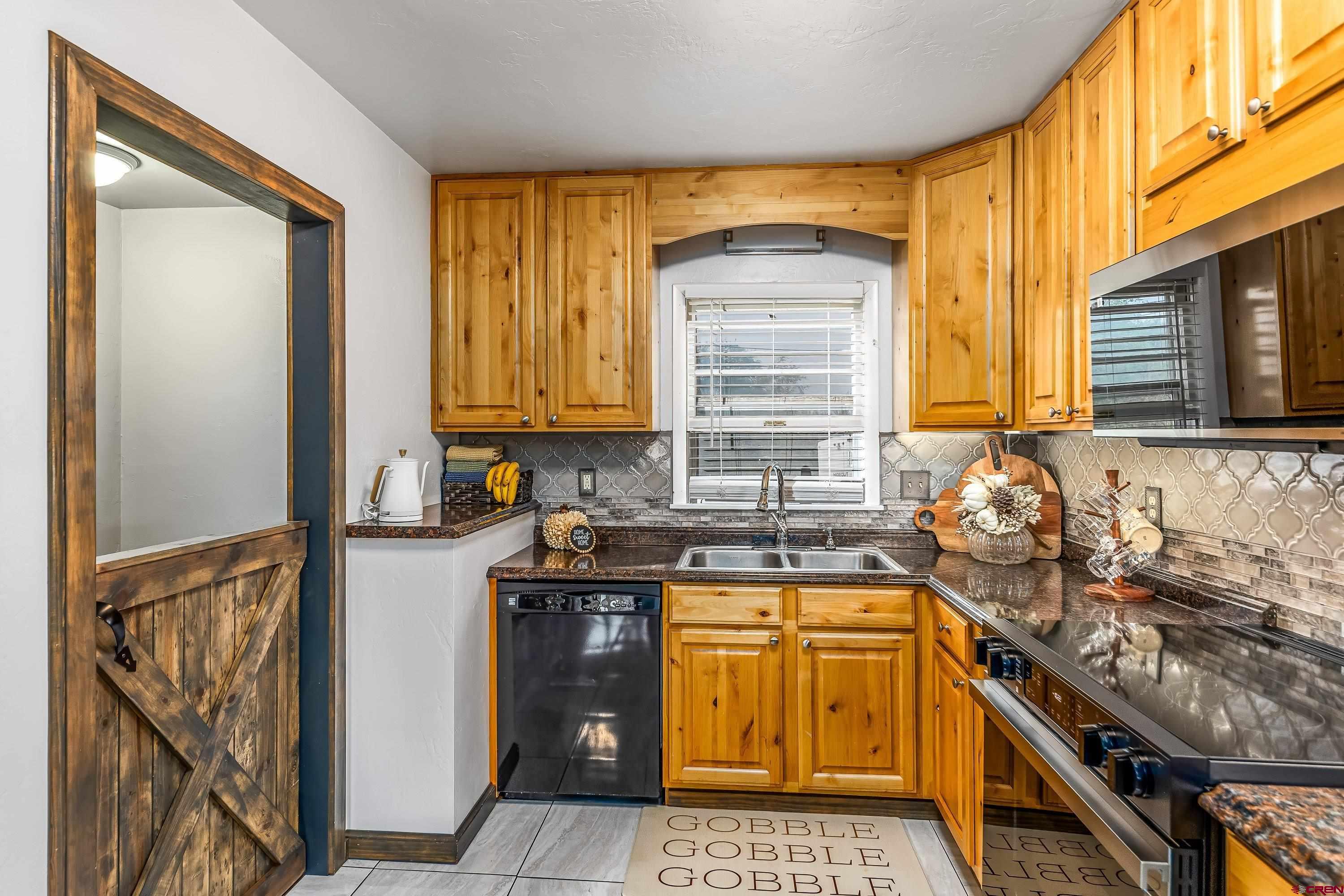 645 Leon Street Delta, CO 81416 - Photo 10 of 28 a kitchen with a sink a stove and cabinets