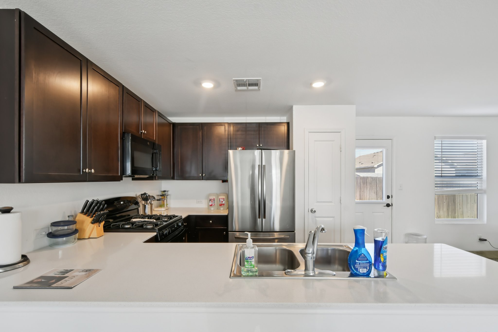14116 Mussel Run Elgin, TX 78621 - Photo 14 of 40 Kitchen featuring black appliances, dark wood finish cabinets, a peninsula, and recessed lighting