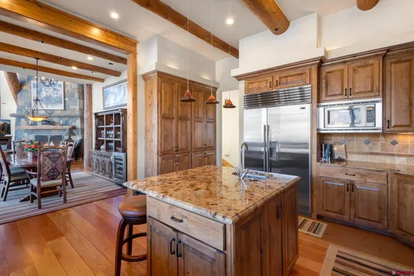 a kitchen with a table chairs refrigerator and cabinets