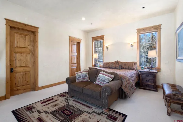 a bedroom with a bed wooden floor and window