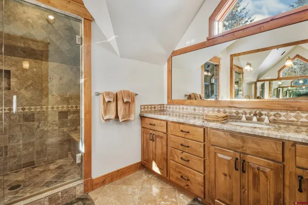 a bathroom with a granite countertop sink mirror and shower