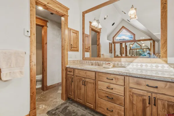 a bathroom with a granite countertop sink and a mirror