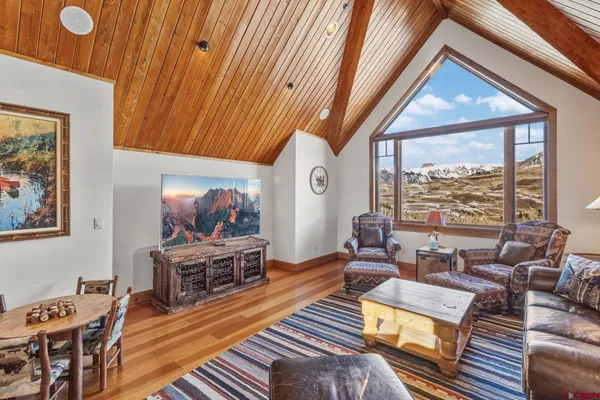 a living room with furniture a flat screen tv and a floor to ceiling window