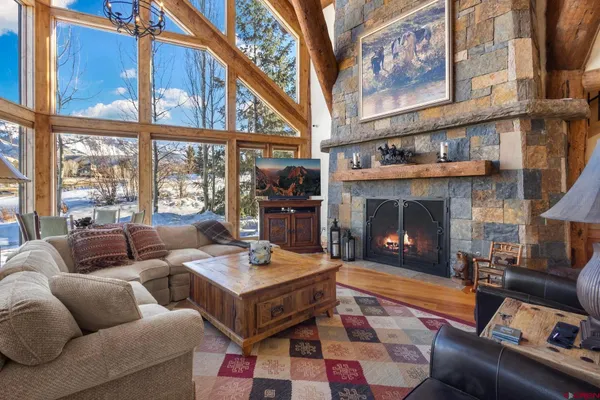a living room with furniture a fireplace and a large window