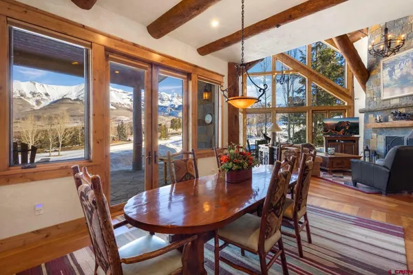 a dining room with furniture a chandelier and wooden floor
