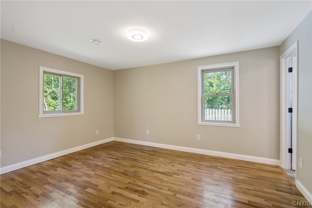 563 County Rte 12 Schroeppel, NY 13132 - Photo 22 of 39 The very sprawling primary bedroom sits in the back corner of the home. Let's peek into this doorway at right...