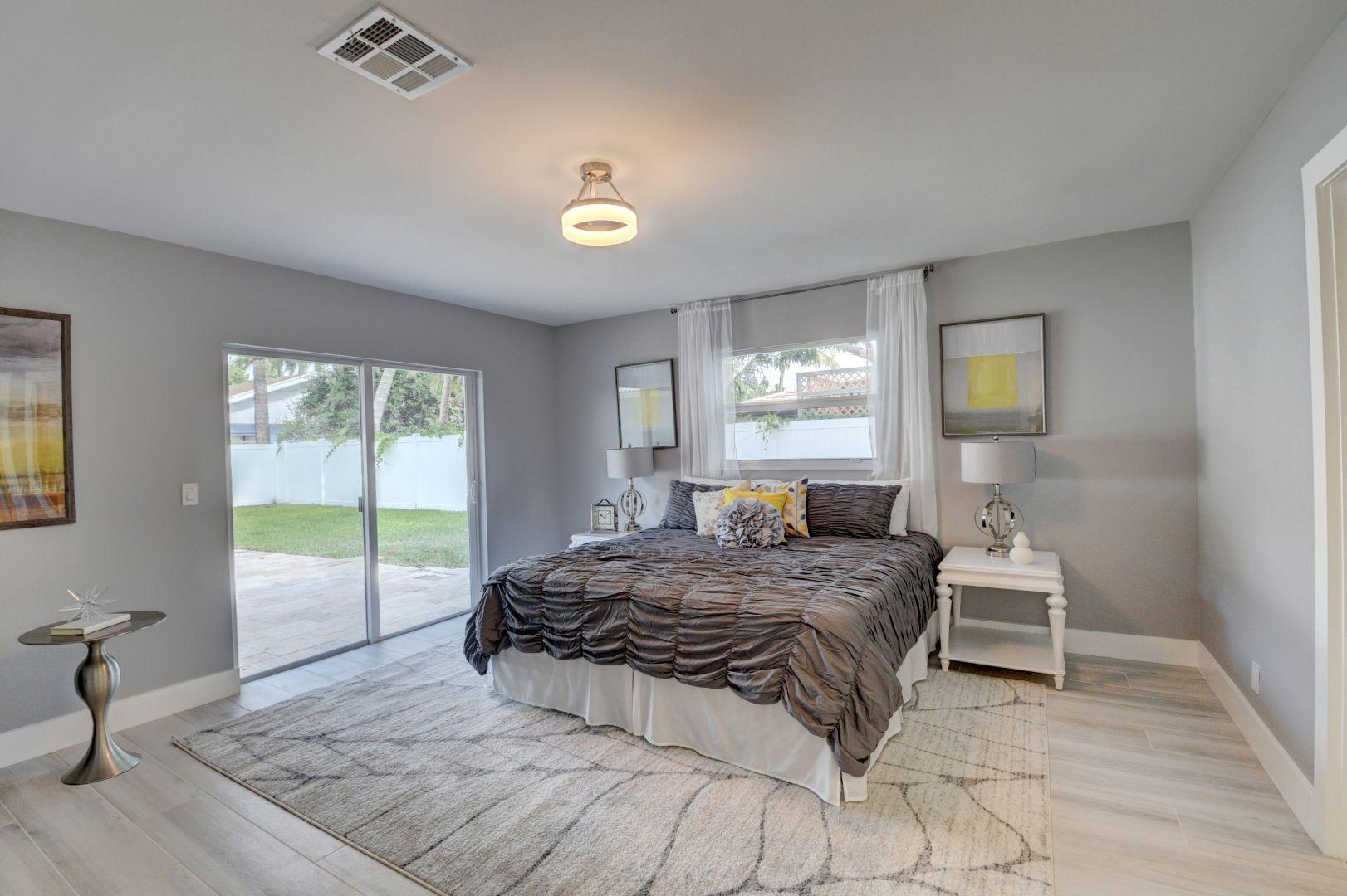 709 Sunshine Drive Delray Beach, FL 33444 - Photo 12 of 25 a bedroom with a bed and wooden floor