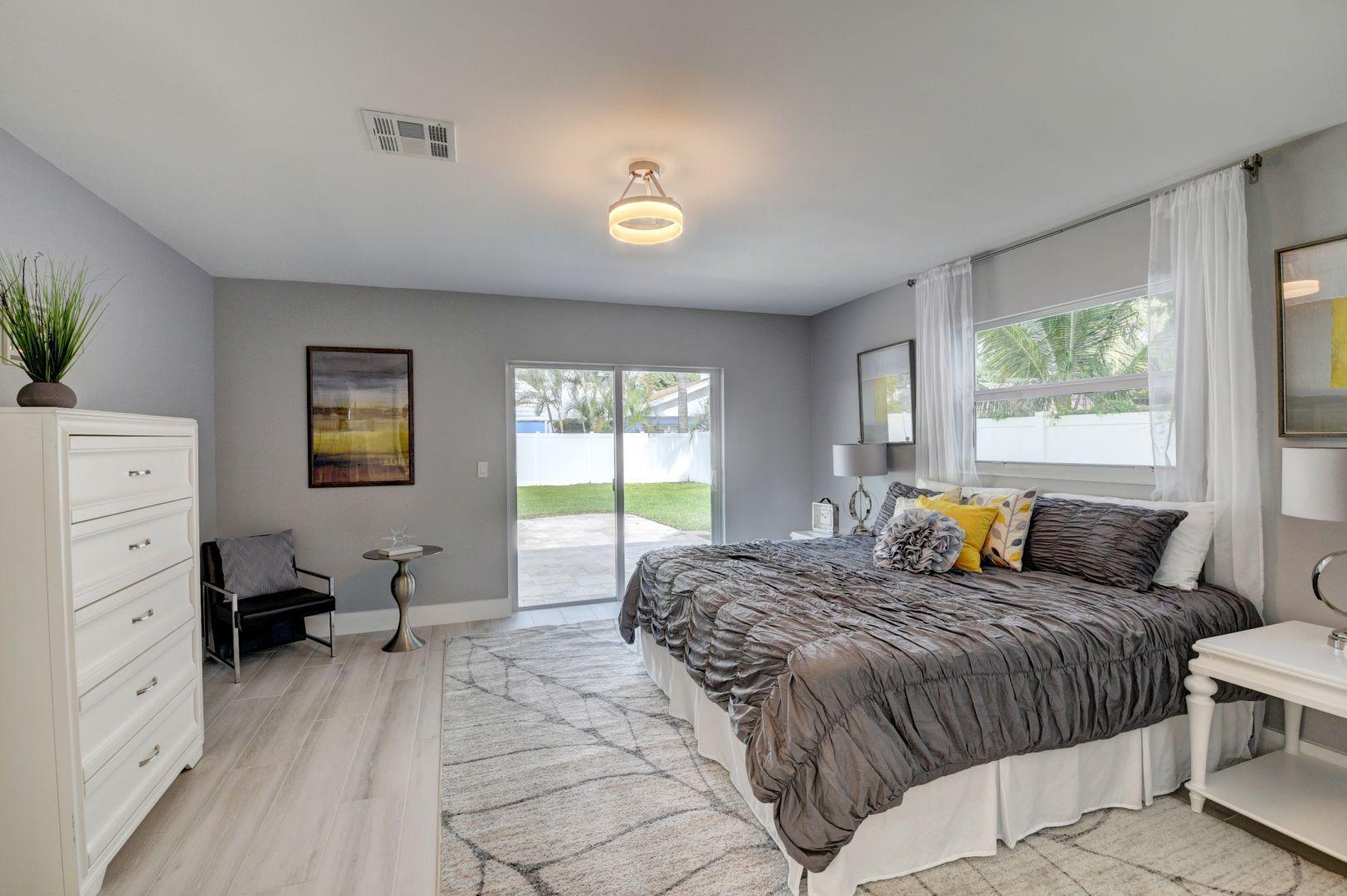 709 Sunshine Drive Delray Beach, FL 33444 - Photo 13 of 25 a spacious bedroom with a large bed and a window