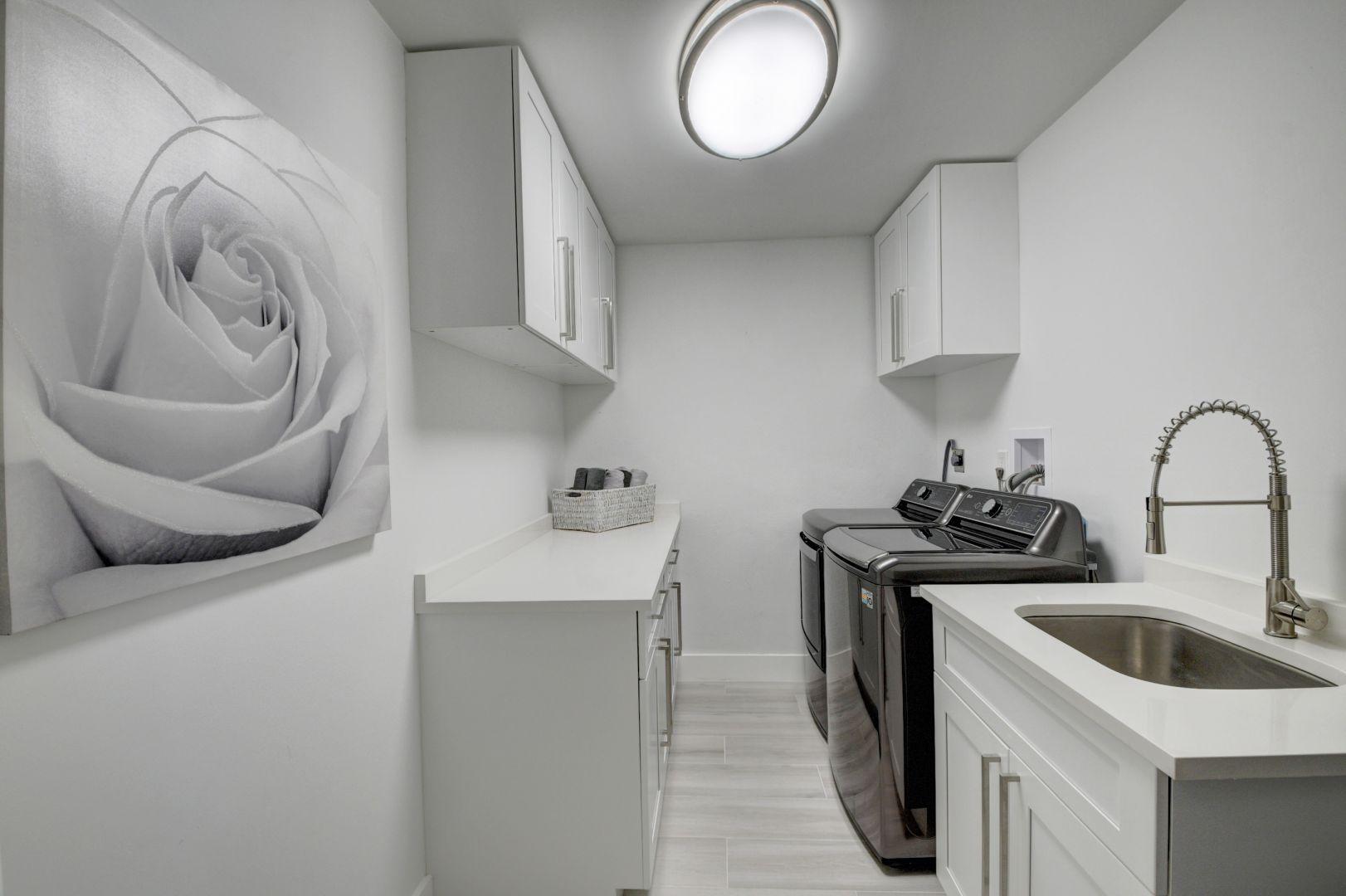 709 Sunshine Drive Delray Beach, FL 33444 - Photo 17 of 25 a kitchen with stainless steel appliances granite countertop a sink a stove and a wooden floor