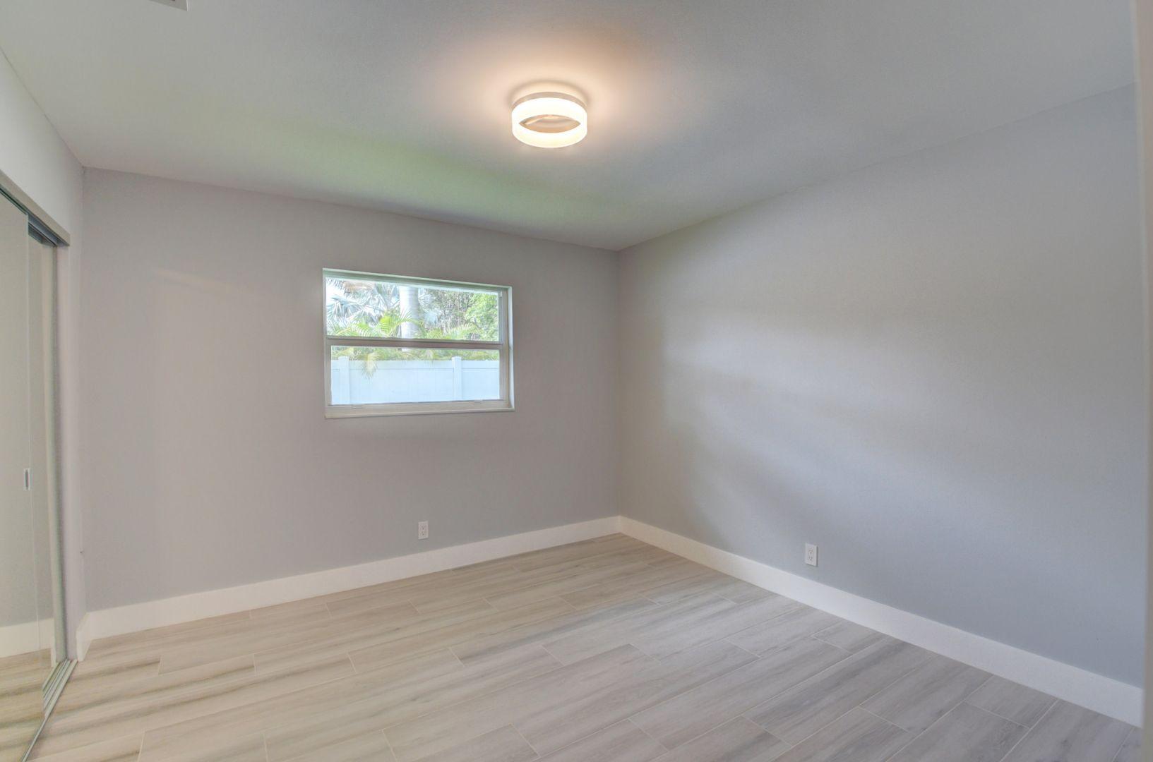 709 Sunshine Drive Delray Beach, FL 33444 - Photo 19 of 25 wooden floor in an empty room with a window