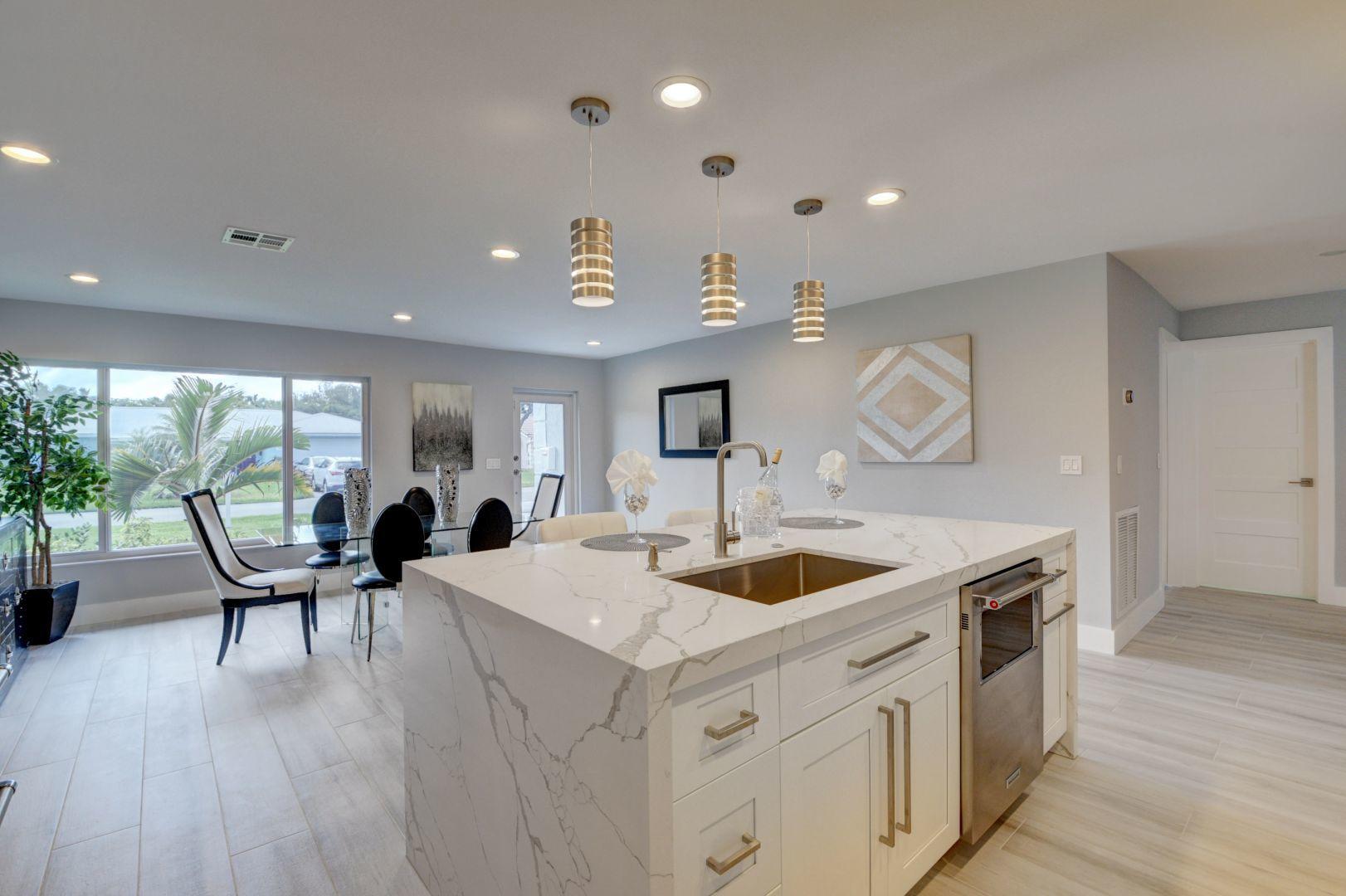 709 Sunshine Drive Delray Beach, FL 33444 - Photo 3 of 25 a view of a kitchen counter space a sink and wooden floor