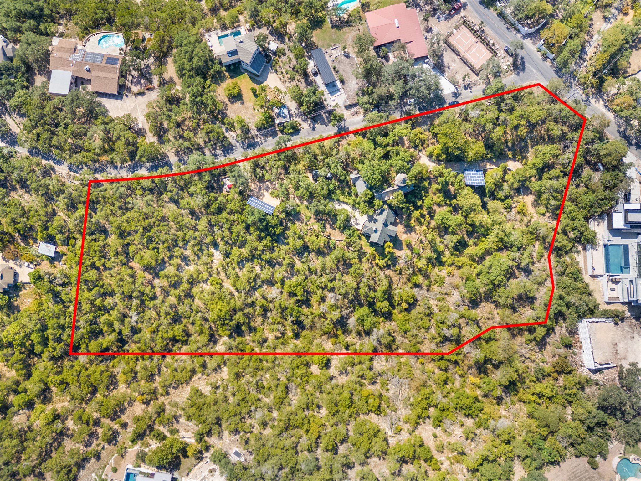 1354 The High Road Austin, TX 78746 - Photo 3 of 40 An aerial perspective reveals a vast, tree-filled lot with a tranquil residential backdrop.