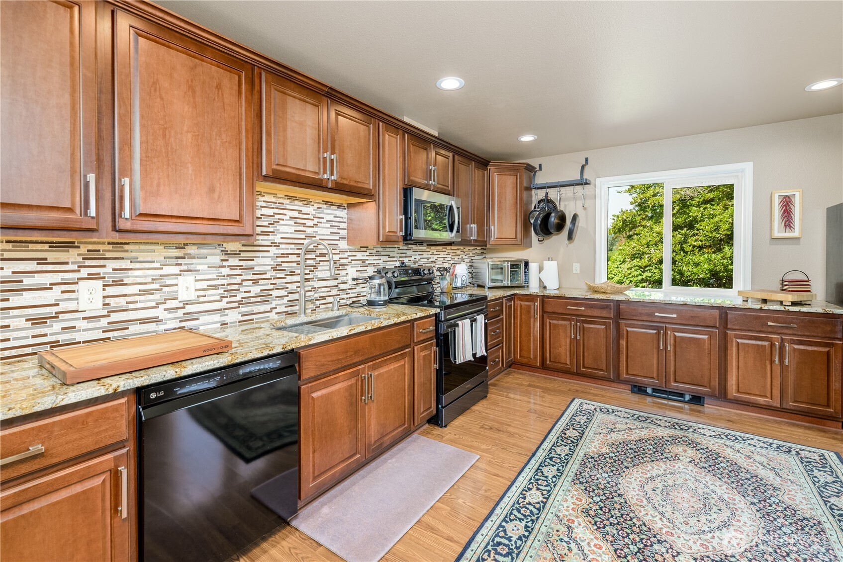 3718 Sequim-Dungeness Way Sequim, WA 98382 - Photo 11 of 40 a kitchen with stainless steel appliances granite countertop wooden cabinets a sink and a stove