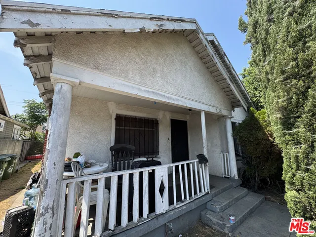 a view of a house with a small yard and wooden fence