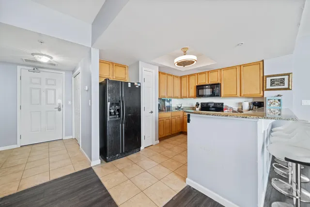 a kitchen with stainless steel appliances granite countertop a refrigerator and a stove top oven