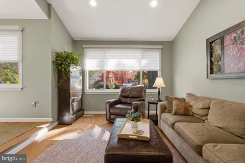 a living room with granite countertop furniture a dining table wooden floor and kitchen view