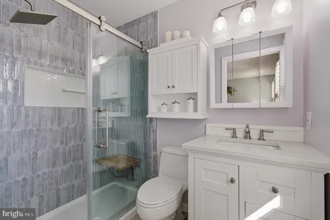 a bathroom with a sink a toilet and shower