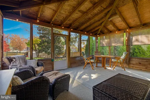 a view of a house with a yard and large trees