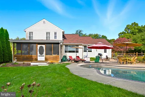 an aerial view of residential houses with outdoor space and trees