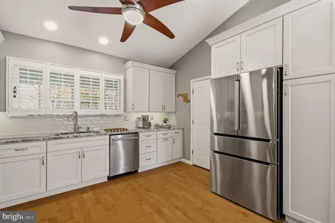 a kitchen with stainless steel appliances granite countertop a stove a sink dishwasher and a refrigerator
